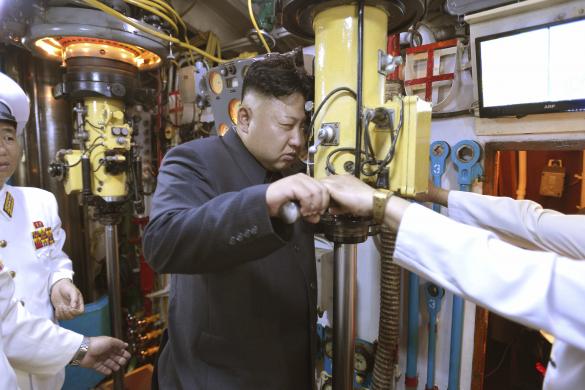 North Korean leader Kim Jong Un looks through a periscope of a submarine during his inspection of the KPA Naval Unit 167