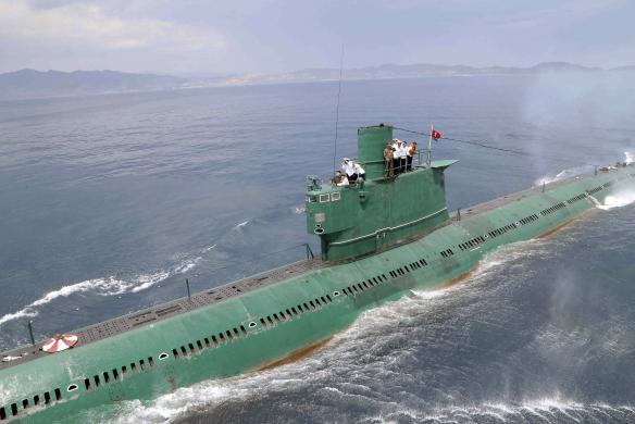 North Korean leader Kim Jong Un stands on the conning tower of a submarine during his inspection of the KPA Naval Unit 167