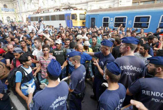 Migrants face Hungarian police in the main Eastern Railway station in Budapest, Hungary, September 1, 2015. Hungary closed Budapest's main Eastern Railway station on Tuesday morning with no trains departing or arriving until further notice, a spokesman for state railway company MAV said. There are hundreds of migrants waiting at the station. People have been told to leave the station and police have lined up at the main entrance, national news agency MTI reported. REUTERS/Laszlo Balogh