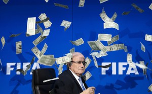 FILES - A picture taken on July 20, 2015 shows FIFA president Sepp Blatter looking on as fake dollar notes fly around him, thrown by a British comedian during a press conference at the FIFA world-body headquarter's in Zurich. Embattled FIFA chief Joseph Blatter is suspected of "disloyal payment" to UEFA head Michel Platini, who had hoped to succeed him, the office of Switzerland's attorney general said on September 25, 2015. AFP PHOTO / FABRICE COFFRINI FABRICE COFFRINI/AFP/Getty Images