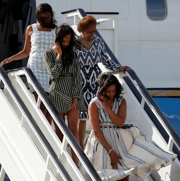 Michelle-Obama-tries-to-control-her-dress-as-she-steps-off-her-plane-with-her-daughters-Sasha-and-Malia-and-mother